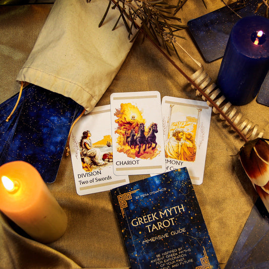 Greek Myth Tarot cards with candles, feathers, and a book on a textured surface